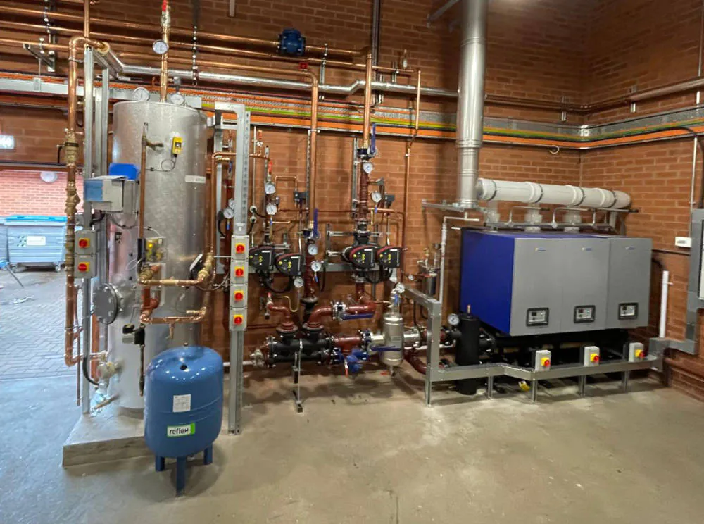 Industrial boiler room with tanks and pipes setup.