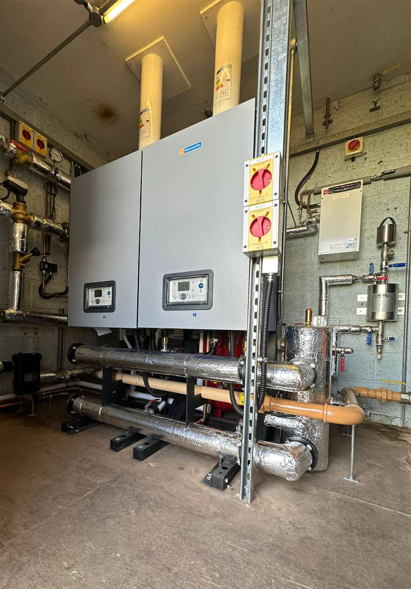 Industrial boiler room with pipes and controls.