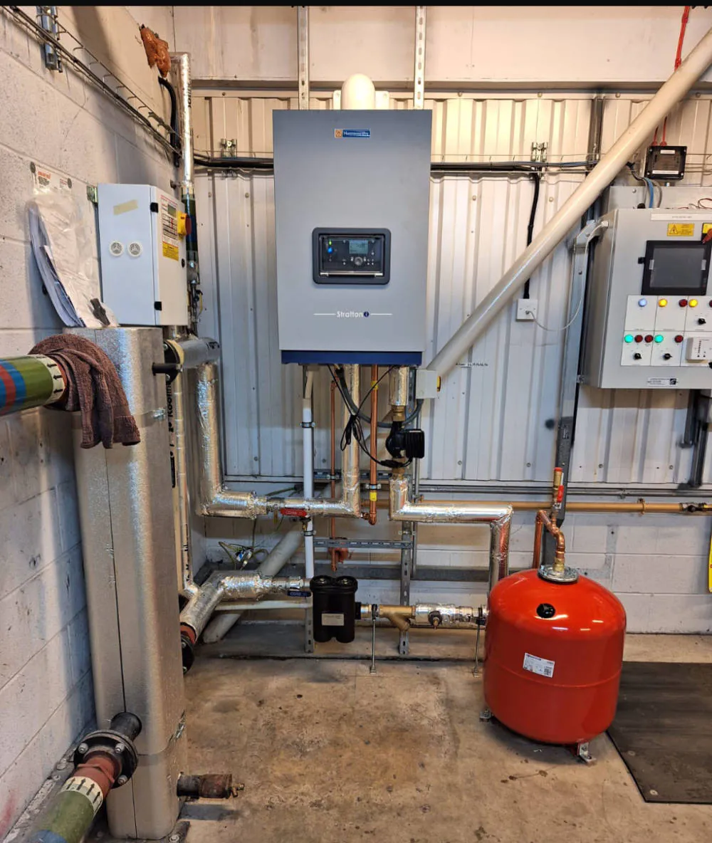 Industrial boiler room with heating equipment and pipes.