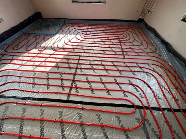 Underfloor heating installation with red pipes.